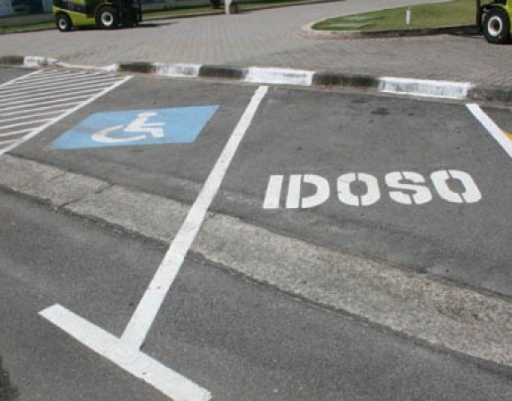 Imagem de um estacionamento. Vaga destinada a pessoas com deficiência à esquerda e a idosos à direita.